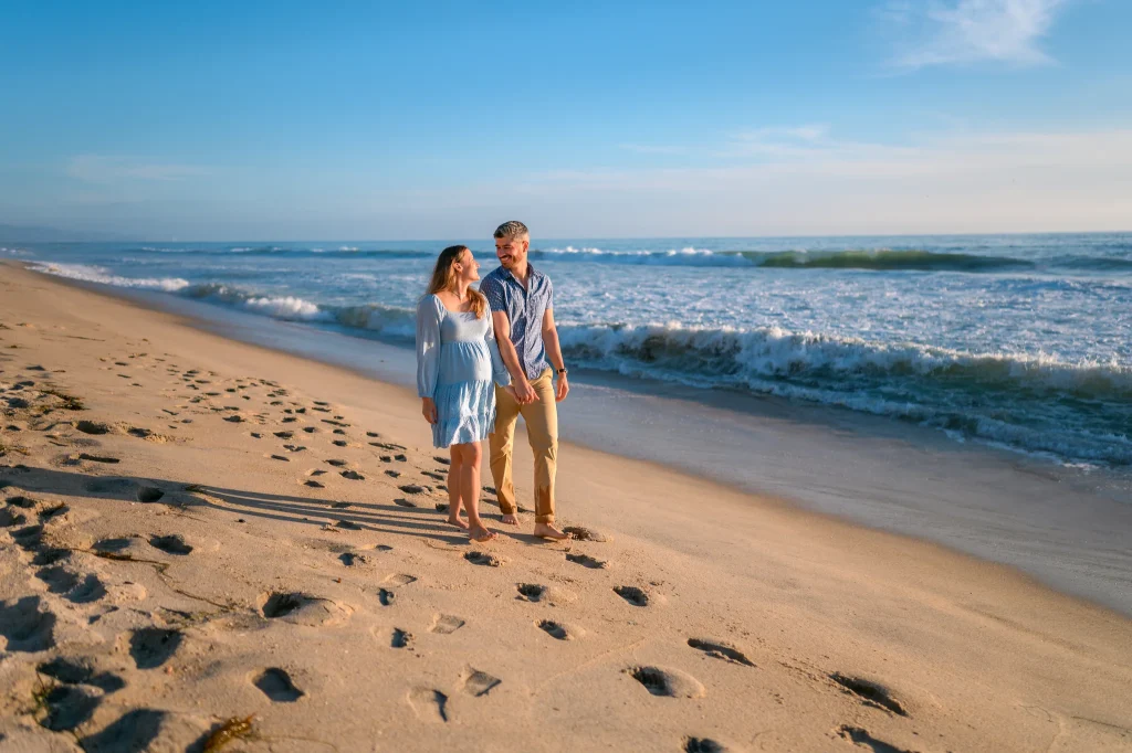 A soulful, unscripted moment of a couple walking along a San Diego beach at sunset, captured by Noah Gilman Productions.