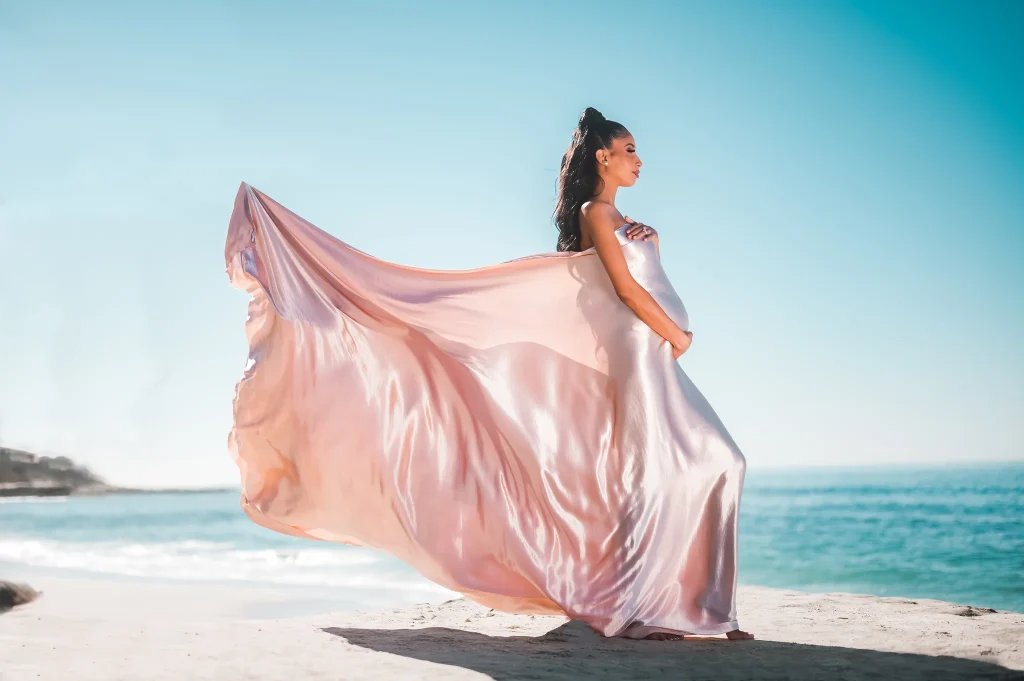 An epic solo maternity portrait at Solana Beach with a flowing dress waving in the wind.